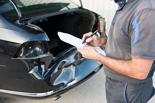 man assessing car bumper repairs